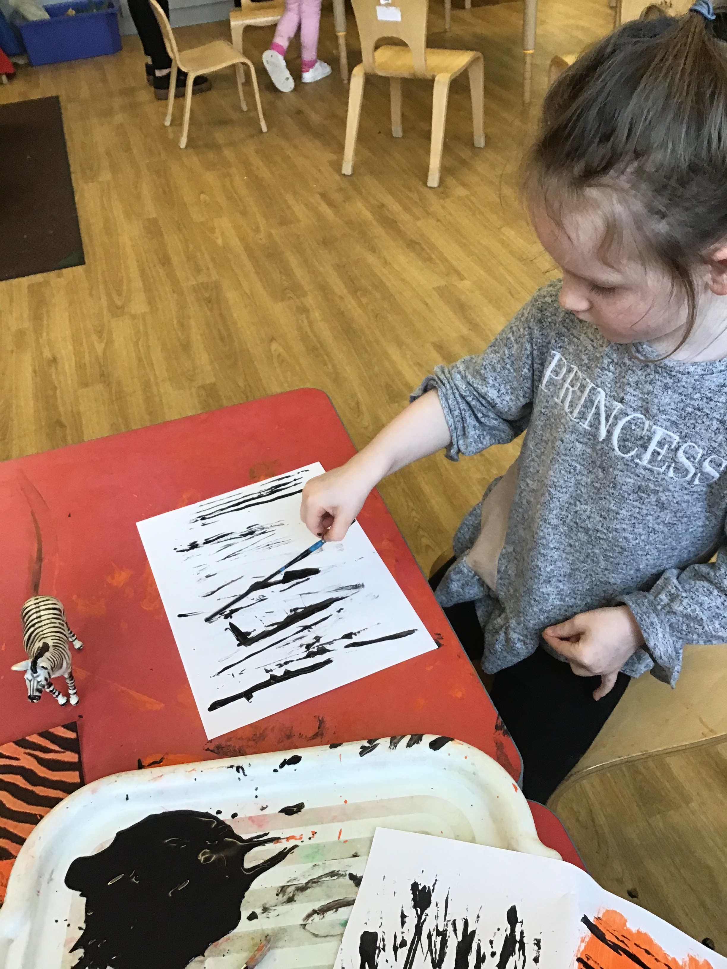 young girl painting a zebra