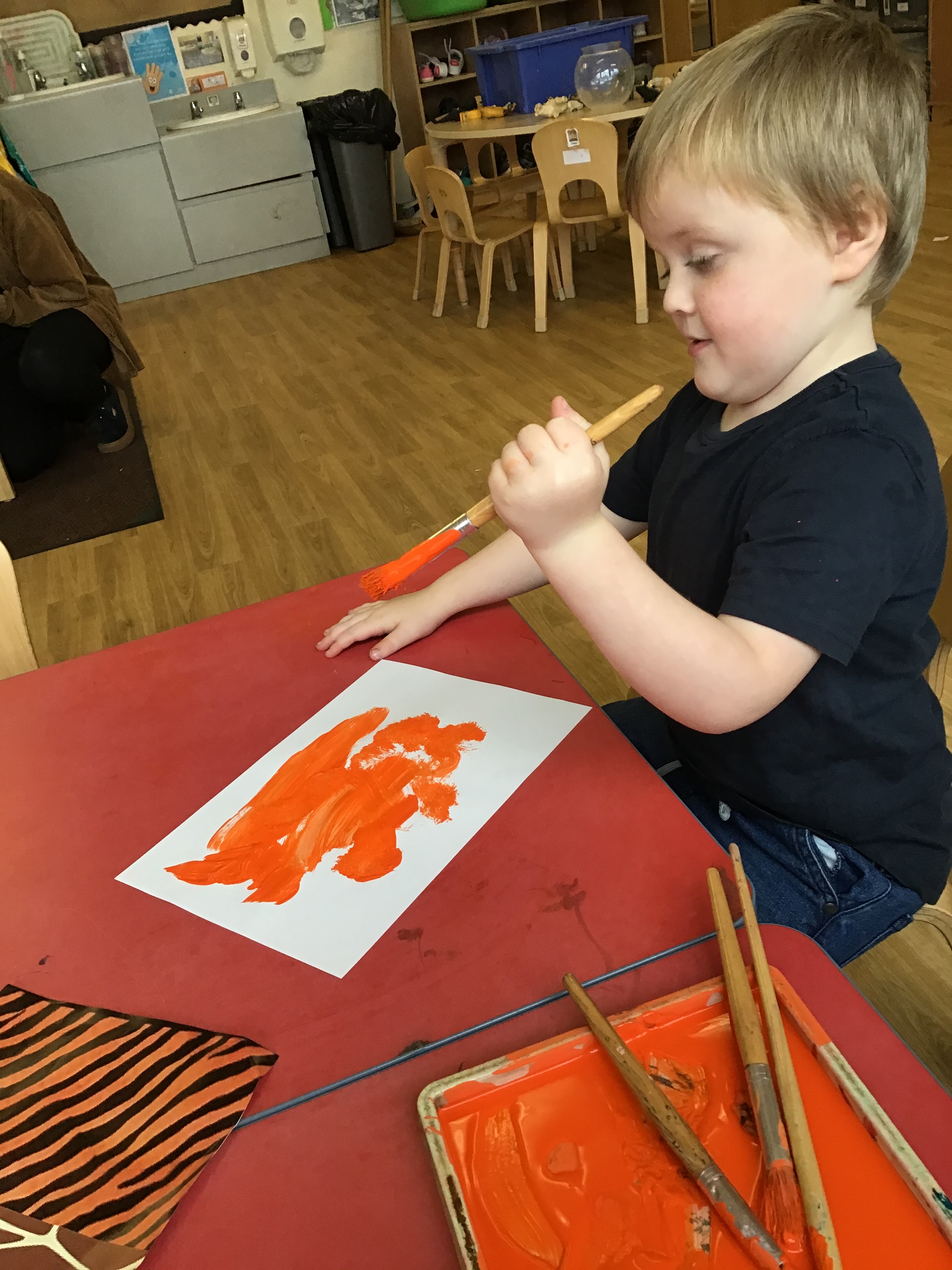 young boy painting tiger stripes